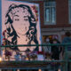 a mural of breonna taylor is lit by candles at a vigil in Portland, Oregon, on the anniversary of her shooting death in 2021