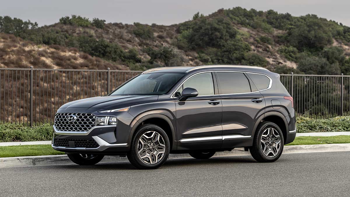 A picture of a 2022 Hyundai Santa Fe SUV in dark charcoal pictured on a road in a desert area