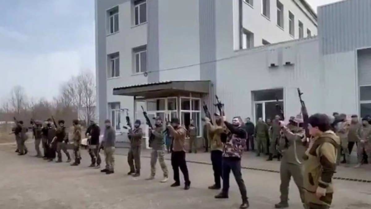 Russian militants stand outside a hotel turned into barracks in Kadiivka, Luhansk, before it was destroyed in a HIMARS attack