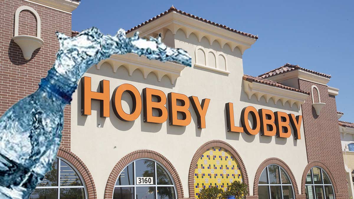 A file photo of the exterior of a Hobby Lobby store with a water bottle superimposed on the left side. Water is coming out of the top of the bottle, framing the left and top of the Hobby Lobby Logo