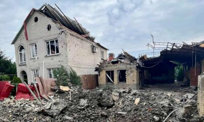 A two story home is badly damaged from a rocket attack in Kramatorsk, the home is leaning to one side with the roof partially torn off and damaged windows, a large crater is in the ground