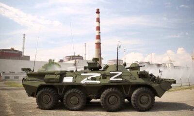 A Russian infantry fighting vehicle with invasion Z markings on it is parked on the grounds of the Zaporizhzhia Nuclear Power Plant, with Reactor 2 clearly visible in the photoby the cooling and aeration fountains of the