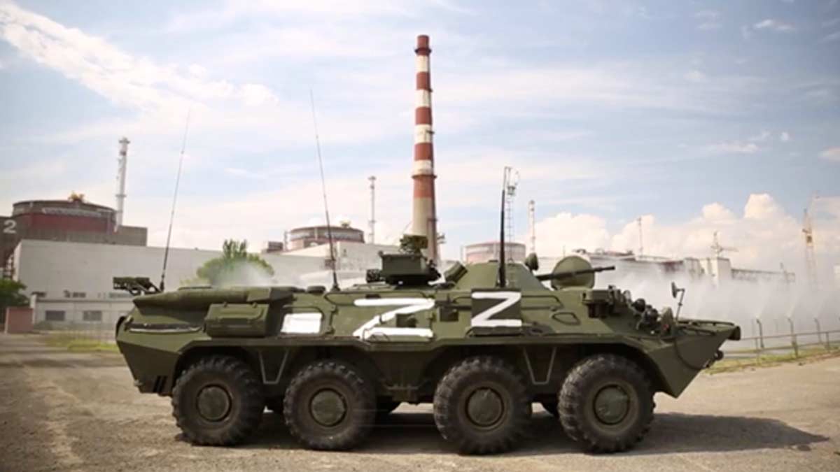 A Russian infantry fighting vehicle with invasion Z markings on it is parked on the grounds of the Zaporizhzhia Nuclear Power Plant, with Reactor 2 clearly visible in the photoby the cooling and aeration fountains of the