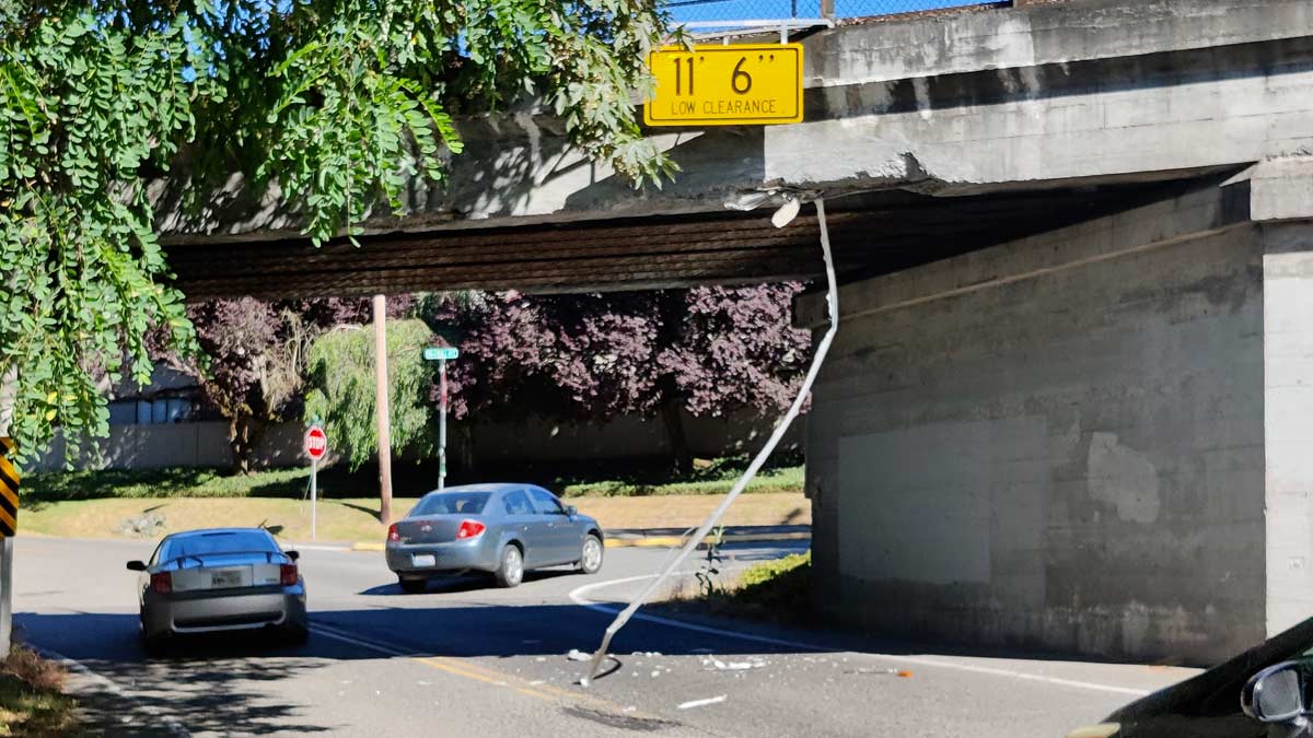 Kirkland Ave truck eating bridge on the west side of the bridge showing concrete in the road and potential structural damage to the bridge after a drive off truck strike