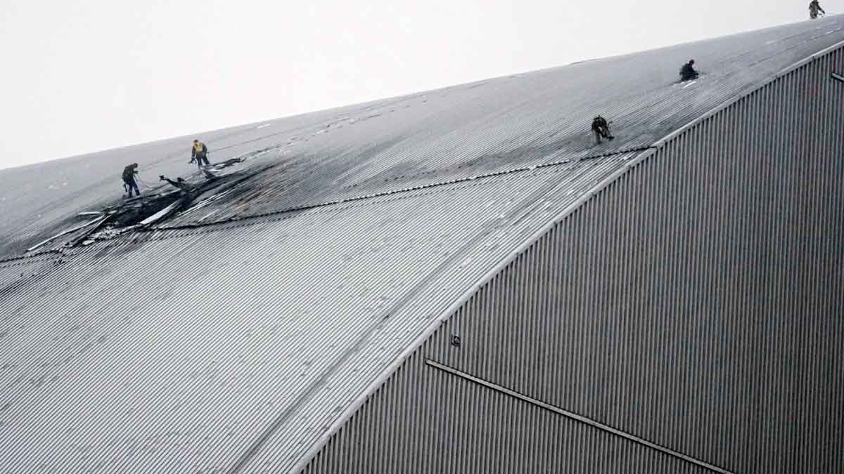 Firefighters and engineers on the roof of the protective structure over Reactor 4 at Chornobyl Nuclear Power Plant after the 14 February Russian drone attack.