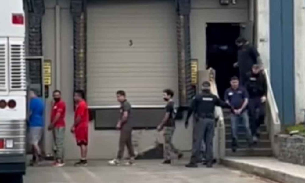 Allegedly undocumented immigrants in handcuffs being loaded onto a bus in Kent, Washington