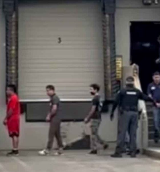 Allegedly undocumented immigrants in handcuffs being loaded onto a bus in Kent, Washington