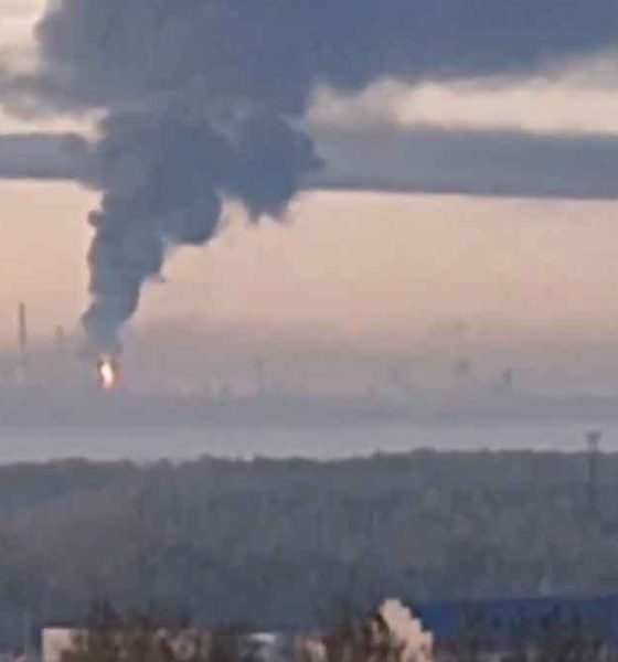 The Yaroslavl Oil Refinery near Moscow is on fire with a large black plume of smoke rising into the air at sunrise.