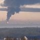 The Yaroslavl Oil Refinery near Moscow is on fire with a large black plume of smoke rising into the air at sunrise.