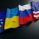 Flags of the European Union, Ukraine, Russia, and the United States lying on a table.