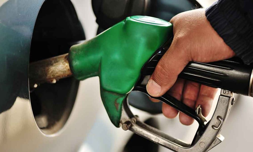 A person's hand pumping gasoline into a vehicle