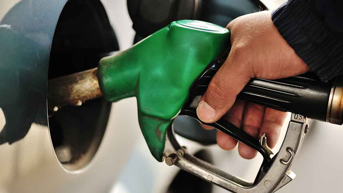 A person's hand pumping gasoline into a vehicle